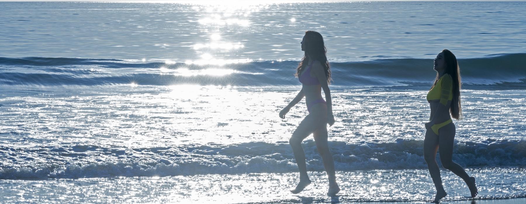 two women walking on the beach