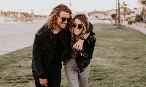 a couple walks on grassy area in open neighborhood lot