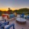 a patio with chairs and tables and a sunset